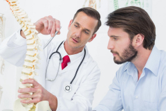 Male doctor explaining the spine to a patient